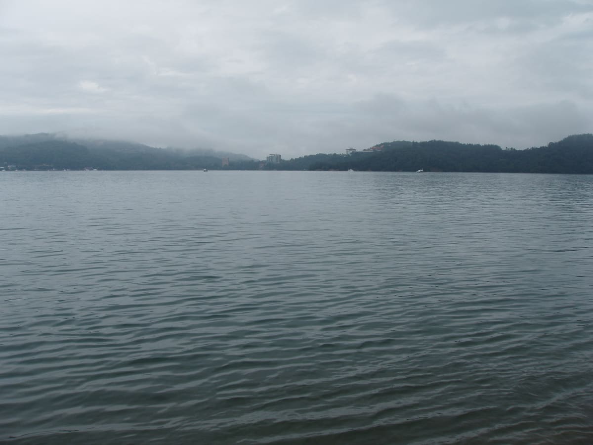 Boote am Pier von Ita Thao, dahinter See und Hügel