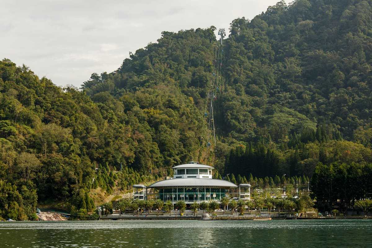 Gondeln der Sonne-Mond-See-Seilbahn über dem bewaldeten Seeufer